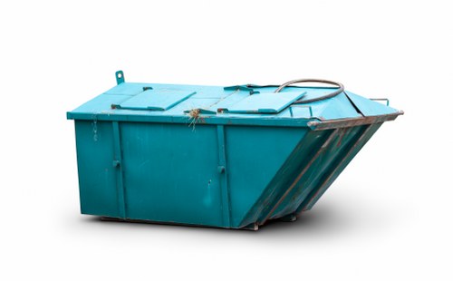 Skip hire vehicle and skip being loaded outside a terraced house in Edmonton