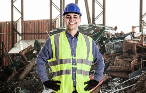 Workers wearing PPE handling waste and operating a skip safely